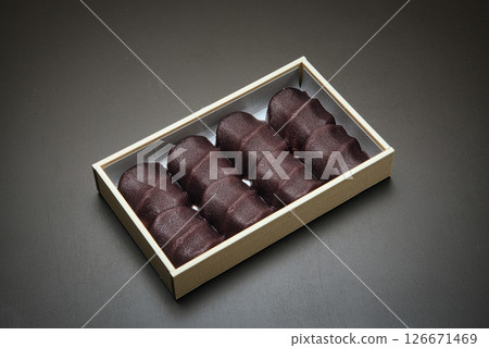 享用這款美味的日本糖果，它由柔軟的麻糬包裹在光滑的豆沙中，並配上一些日本茶。 126671469