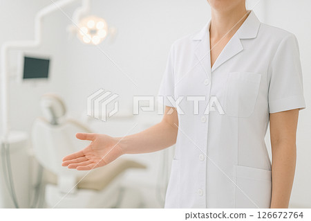 Dentist inviting patient into dental clinic 126672764