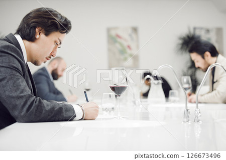 Professional Sommeliers Participants Tasting Red Wine during Blind Degustation. Contest in Sommelier School. 126673496