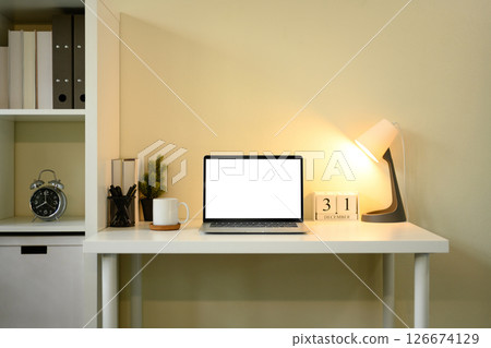 Clean workspace with laptop, notebooks, and pencil holder near a window with blinds Clean workspace with laptop, notebooks, and pencil holder near a window with blinds 126674129