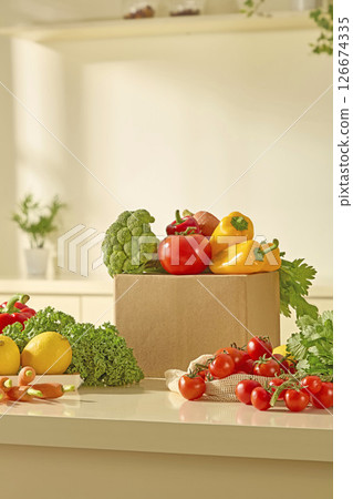Fresh fruits and vegetables such as kale, tomatoes, bell peppers and oranges are displayed on a clean beige countertop, creating a bold contrast and a message of healthy living. 126674335