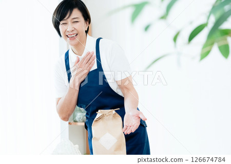 A female home helper arranging ingredients on a table 126674784