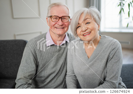 Senior adult mature couple hugging at home. Mid age old husband and wife embracing with tenderness love enjoying sweet bonding wellbeing. Grandmother grandfather together. Family moment love and care 126674924