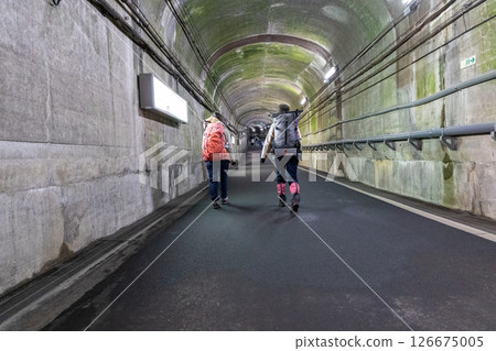 Climbers walking through the tunnel towards Kurobe Dam Station 126675005