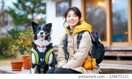 A dog and a woman in her twenties sheltering from the rain 126675121