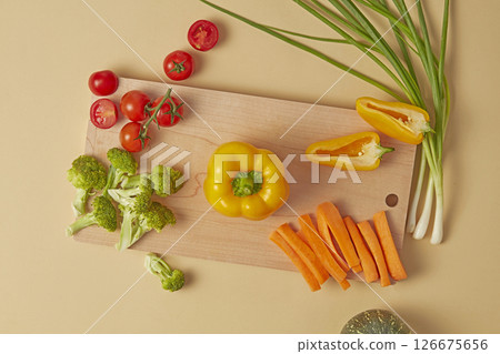 Artistic flat-lay of green vegetables and fruit arranged symmetrically on a rustic beige background. Includes broccoli, zucchini, cucumber, and mint, ideal for organic food themes Artistic flat-lay of green vegetables and fruit arranged symmetrically on a rustic beige background. Includes broccoli, zucchini, cucumber, and mint, ideal for organic food themes 126675656