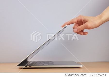 female hand open or close laptop on beige table, side view female hand open or close laptop on beige table, side view 126675741