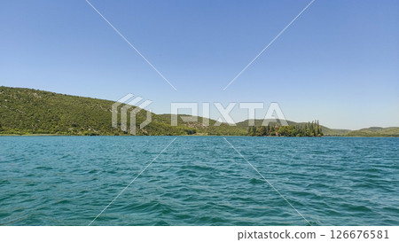 Visovac monastery island on krka river reflecting on turquoise water in croatia Visovac monastery island on krka river reflecting on turquoise water in croatia 126676581