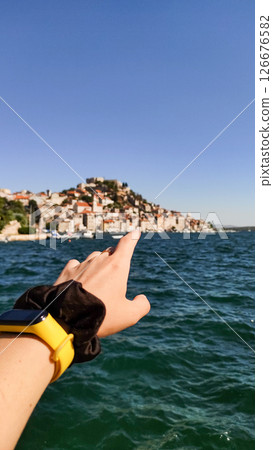 Tourist pointing at sibenik city skyline during summer vacation in croatia Tourist pointing at sibenik city skyline during summer vacation in croatia 126676582