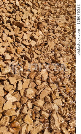 Crystal clear water flowing over smooth pebbles 126676588