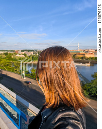 Young woman admiring prague cityscape from a rooftop at sunset letna park 126676598