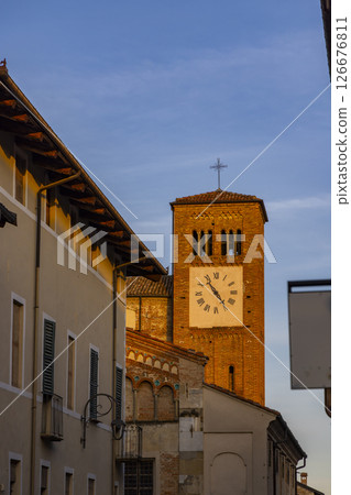 Church tower with clock illuminating during golden hour in Cherasco, Italy 126676811
