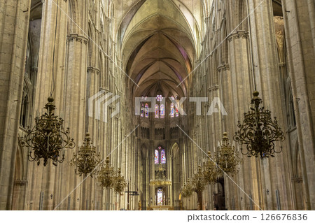 Interior of Bourges Cathedral showing stained glass windows and chandeliers 126676836