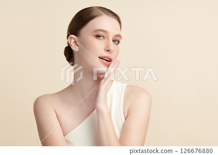 A beautiful young woman with clean, fresh skin against a beige background. Skincare, facial treatment, cosmetology, beauty, and spa. An elegant portrait of an woman. A beautiful young woman with clean, fresh skin against a beige background. Skincare, facial treatment, cosmetology, beauty, and spa. An elegant portrait of an woman. 126676880