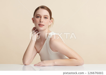 A beautiful young woman with clean, fresh skin against a beige background. Skincare, facial treatment, cosmetology, beauty, and spa. An elegant portrait of an woman. A beautiful young woman with clean, fresh skin against a beige background. Skincare, facial treatment, cosmetology, beauty, and spa. An elegant portrait of an woman. 126676881