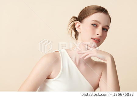 A beautiful young woman with clean, fresh skin against a beige background. Skincare, facial treatment, cosmetology, beauty, and spa. An elegant portrait of an woman. A beautiful young woman with clean, fresh skin against a beige background. Skincare, facial treatment, cosmetology, beauty, and spa. An elegant portrait of an woman. 126676882