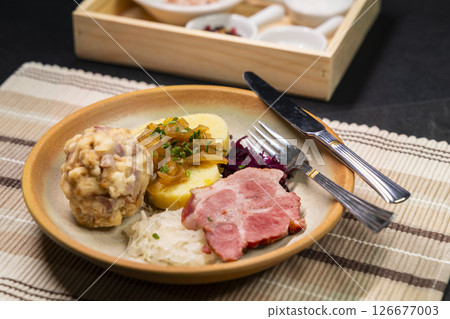 Bavarian dumplings with roasted pork, sauerkraut and potato dumpling lying on a plate 126677003