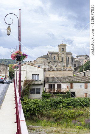 Saint Hilaire Abbey church rising over stone wall in Aude, France Saint Hilaire Abbey church rising over stone wall in Aude, France 126677033