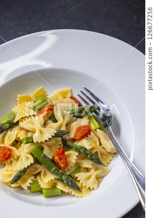 Farfalle pasta with green asparagus, cherry tomatoes and chicken 126677256