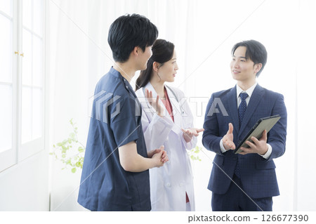 一名西裝筆挺的男子正在向醫護人員做報告 126677390