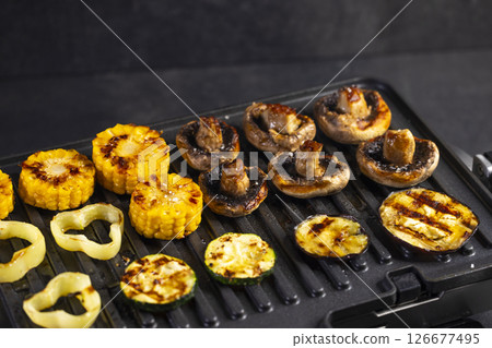 Delicious grilled vegetables cooking on an electric grill, perfect for a healthy and flavorful meal Delicious grilled vegetables cooking on an electric grill, perfect for a healthy and flavorful meal 126677495