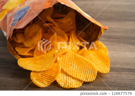 Potato chips, delicious BBQ seasoning spicy for crips, thin slice deep fried snack fast food in open bag. Potato chips, delicious BBQ seasoning spicy for crips, thin slice deep fried snack fast food in open bag. 126677579