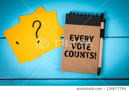 Every Vote Counts. Notebook, Pen, and Question Mark Cards on Blue Table Every Vote Counts. Notebook, Pen, and Question Mark Cards on Blue Table 126677709