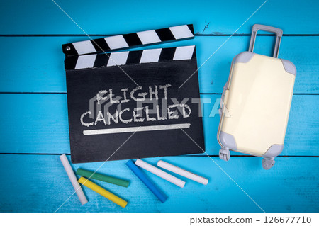 Flight Cancelled Concept with Clapperboard, Chalk and Suitcase on Blue Wooden Background Flight Cancelled Concept with Clapperboard, Chalk and Suitcase on Blue Wooden Background 126677710