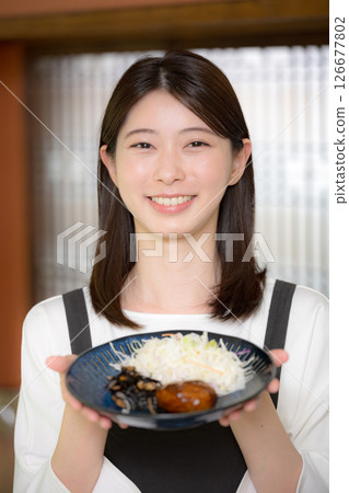 A woman serving rice, looking at the camera, saying "Rice is ready" 126677802