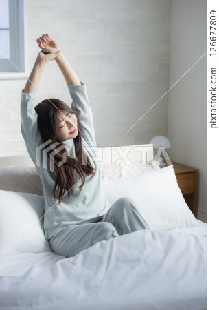 A woman stretching in bed 126677809
