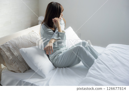 A woman stretching in bed A woman stretching in bed 126677814