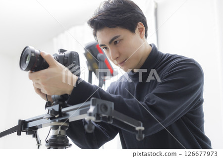 Male cameraman taking a video 126677973