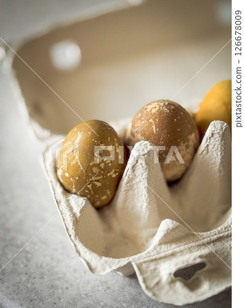 Close-up of fresh brown eggs in a sustainable cardboard egg tray with natural lighting and shallow depth of field. Close-up of fresh brown eggs in a sustainable cardboard egg tray with natural lighting and shallow depth of field. 126678009