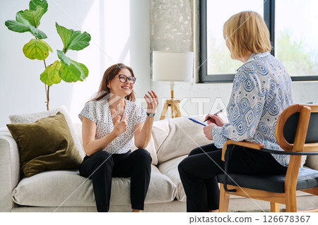 Positive middle aged woman at therapy session in psychologist therapist office Positive middle aged woman at therapy session in psychologist therapist office 126678367