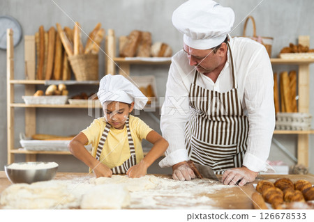 Bakers dad teaches his daughter niece to knead dough 126678533