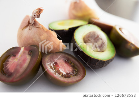 Vegetables black tomatoes, avocado and onions on white background 126678558