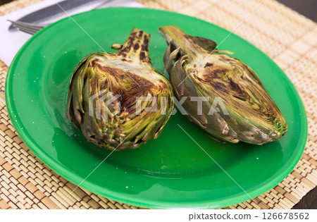 Cooked fried halves artichokes on green plate Cooked fried halves artichokes on green plate 126678562