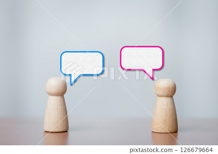 Wooden Figurines Facing Each Other with Speech Bubbles Showing Conversation and Dialogue 126679664