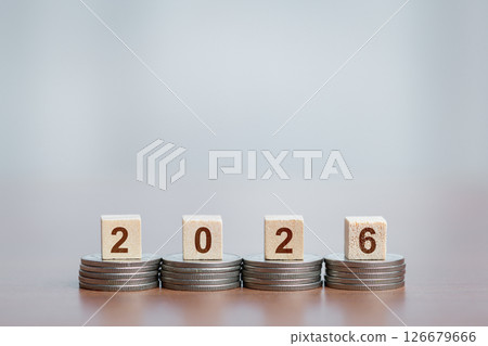 Stacked Coins Supporting Wooden Blocks Showing '2026', Financial Growth and Future Planning Concept 126679666