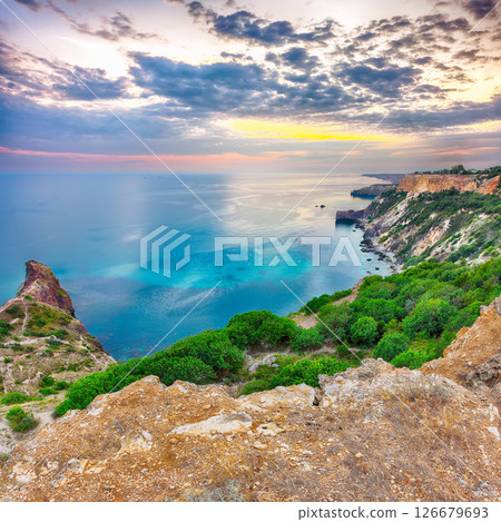 Mesmerizing sunset at cape Fiolent with bushes grass and rocks at foreground Mesmerizing sunset at cape Fiolent with bushes grass and rocks at foreground 126679693
