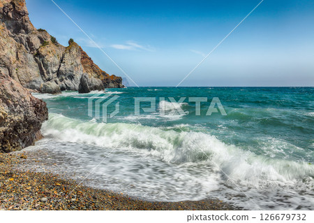 Amazing view of sea waves crashing on the shore and flowing above seashore pebbles 126679732