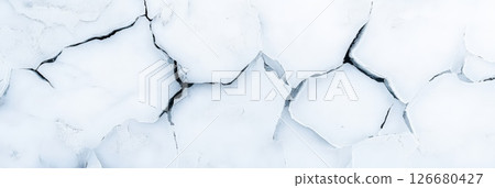 Dry, cracked earth creating intricate patterns under bright sunlight, emphasizing the profound effects of climate change and drought on the fragile environment 126680427