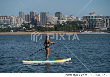 Caucasian woman posing on a SUP board. Summer sport. Caucasian woman posing on a SUP board. Summer sport. 126681342