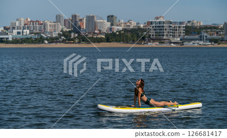 Caucasian woman doing yoga on a SUP board. Caucasian woman doing yoga on a SUP board. 126681417