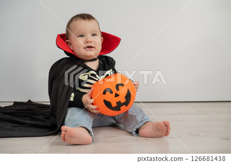 Cute caucasian boy in dracula halloween costume holding candy basket on white background. Cute caucasian boy in dracula halloween costume holding candy basket on white background. 126681438