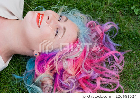 Caucasian woman with colorful hair on green grass. 126681524