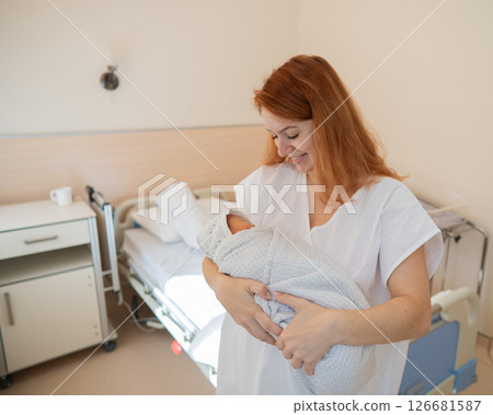Caucasian woman holding newborn son in maternity hospital ward. Caucasian woman holding newborn son in maternity hospital ward. 126681587