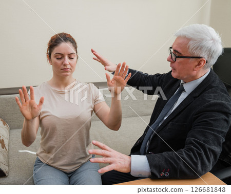 Elderly male hypnotherapist with a female patient. An alternative way to heal mental health Elderly male hypnotherapist with a female patient. An alternative way to heal mental health 126681848