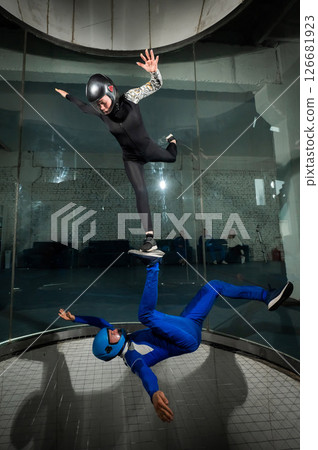 A man and a woman enjoy flying together in a wind tunnel. Free fall simulator A man and a woman enjoy flying together in a wind tunnel. Free fall simulator 126681923