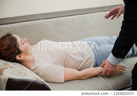 Elderly male hypnotherapist with a female patient. An alternative way to heal mental health Elderly male hypnotherapist with a female patient. An alternative way to heal mental health 126682053